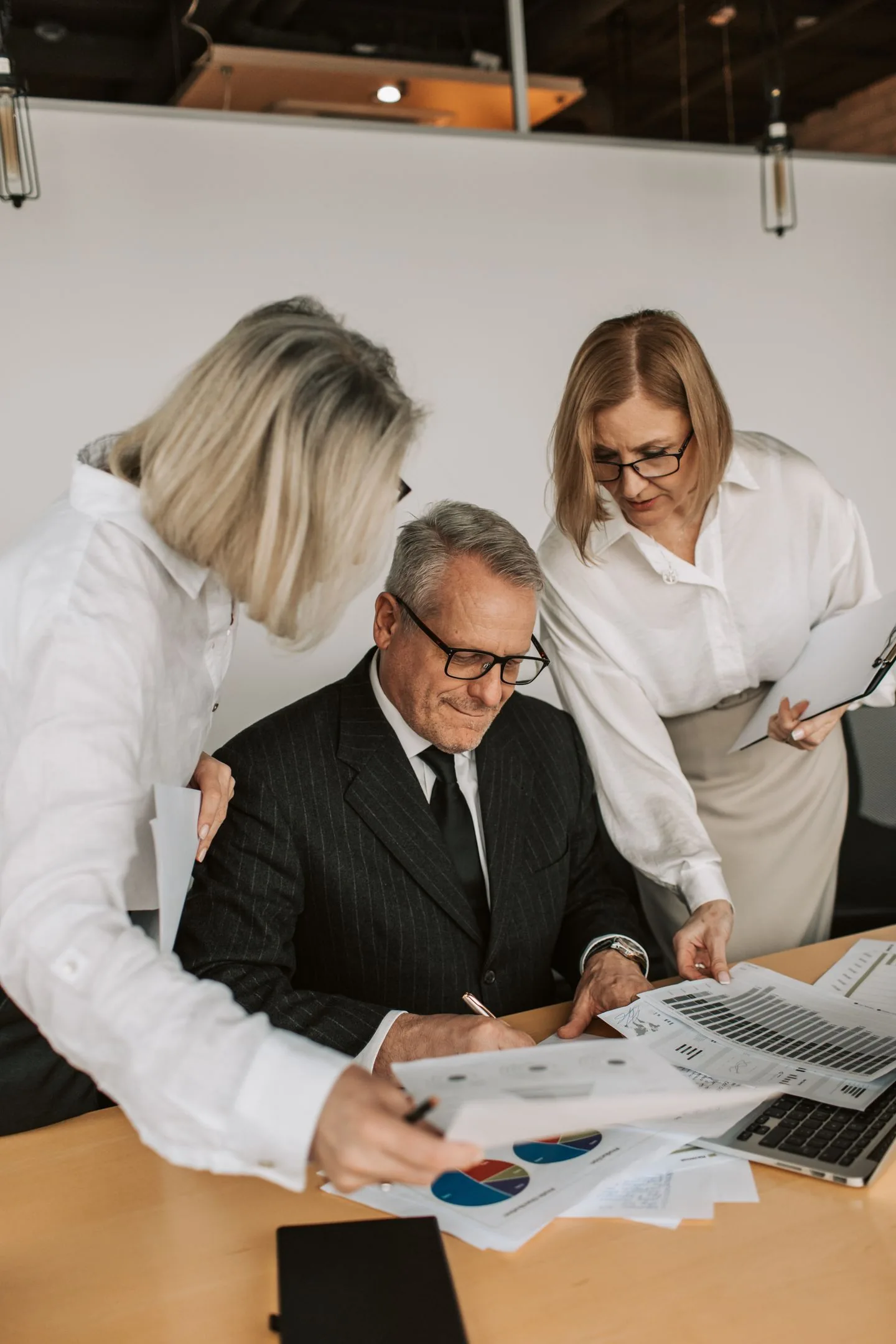 Trois professionnels examinent ensemble des documents de gestion