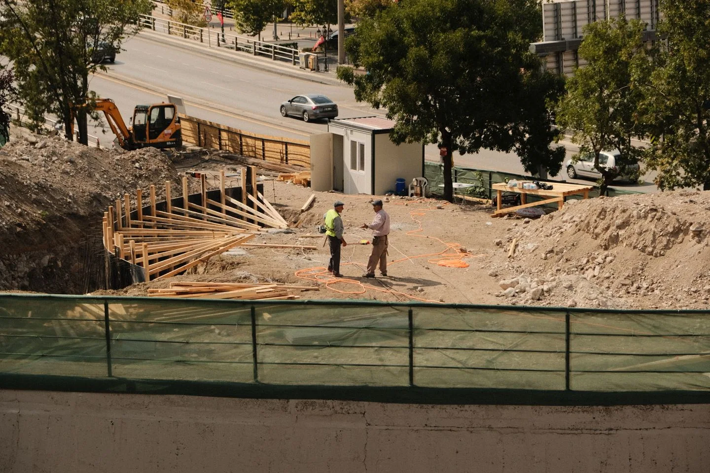 Deux personnes en tenue de chantier échangent sur un site de travaux